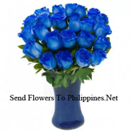 24 roses bleues avec quelques fougères dans un vase en verre