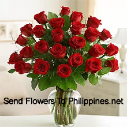 24 roses rouges avec quelques fougères dans un vase en verre