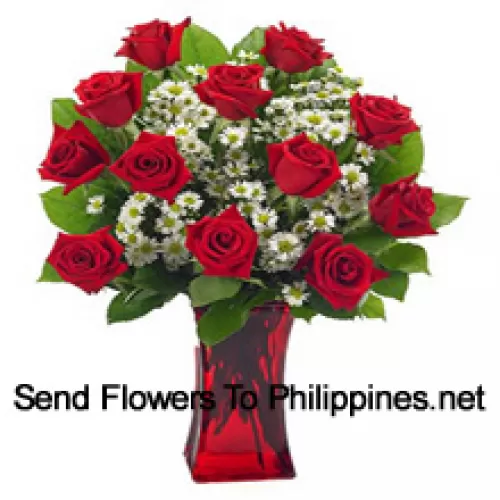 12 roses rouges avec quelques fougères dans un vase en verre