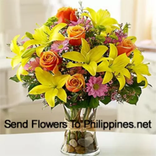 Yellow Lilies, Orange Roses And Pink Gerberas With Seasonal Fillers In A Glass Vase