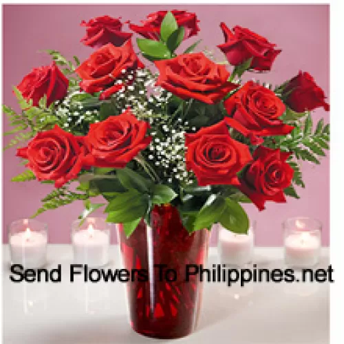 12 rote Rosen mit einigen Farnen in einer Glasvase