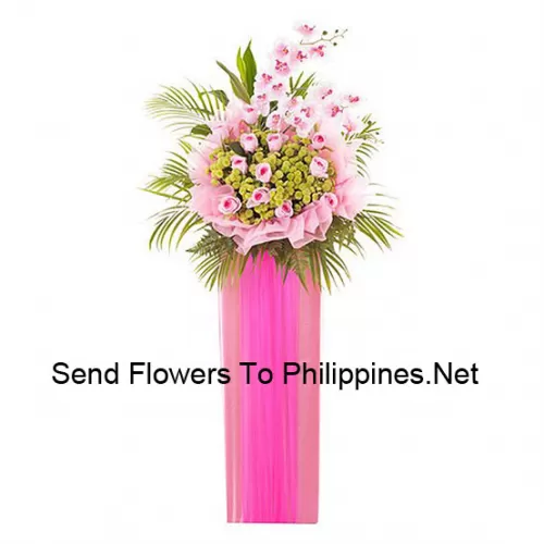 A Tall Congratulatory Stand Made Of Pink Roses And Other Assorted Pink Flowers With Ferns And Fillers