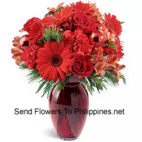 A beautiful holiday red glass vase holds an array of crimson blossoms. Carnations, roses, Gerbera daisies and alstroemeria are decorated with shiny red glass ornaments and interspersed with Christmas greens. Great to give, or to keep for yourself!  (Please Note That We Reserve The Right To Substitute Any Product With A Suitable Product Of Equal Value In Case Of Non-Availability Of A Certain Product)